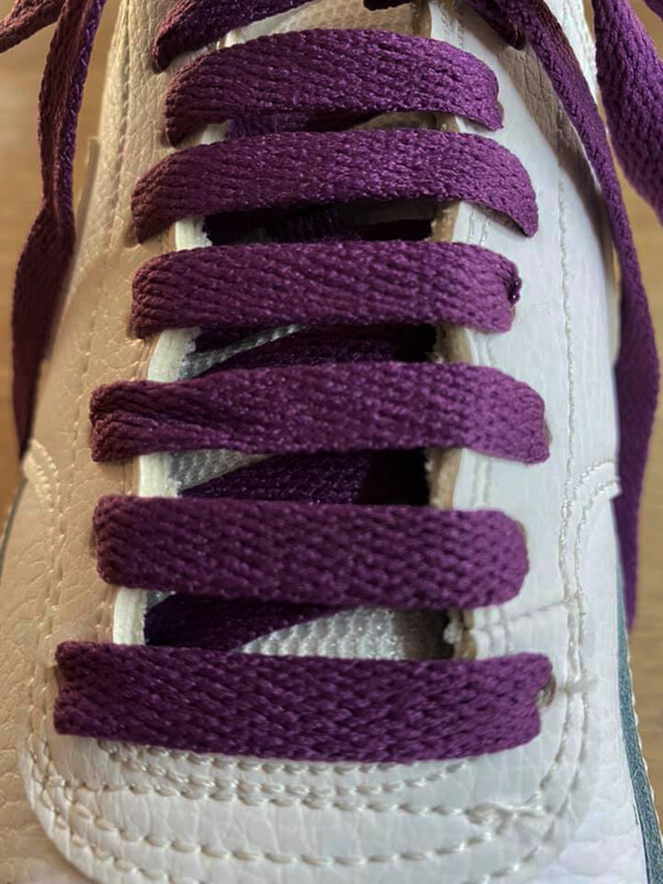 Flat shoelaces in a dark purple plum color, made from recycled materials.