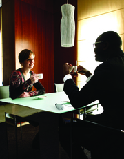 man and woman at shared table, using a Pocketalker.