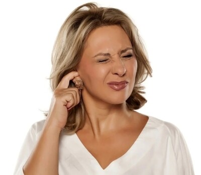Woman scratching at her ear, upset about ear wax