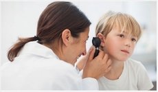 Ear specialist using otoscope to examine a child&#39;s ears