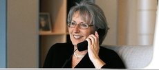 A woman talking on an amplified telephone