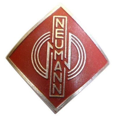 Metal alloy diamond shaped name badge Neumann 077289 with three stylised concentric rings over red on a white background