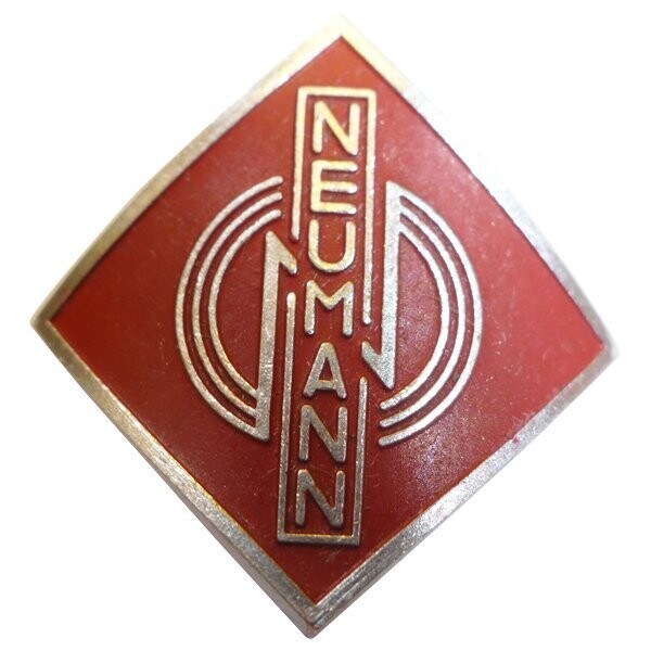 Curved diamond shape metal name badge with red enamel a relief motto around Neumann lettering in caps on white background