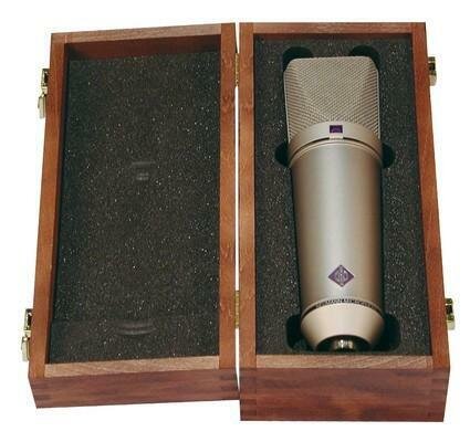 Open Wooden box with hinge on longest edge foam inserts one with a cut-out containing a Neumann U87 Microphone against white