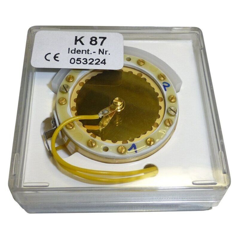 Neumann clear square Perspex container holding golden coloured K87 capsule part 053224 with two yellow wires