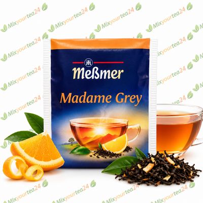 Meßmer Madame Grey – Aromatisierter Schwarztee mit Bergamotte-Orangen-Geschmack, einzeln verpackter Teebeutel 1,75 g Meßmer Madame Grey Schwarztee mit Orange, Teetasse und Teeblättern auf weißem Mixyourtea24-Hintergrund.