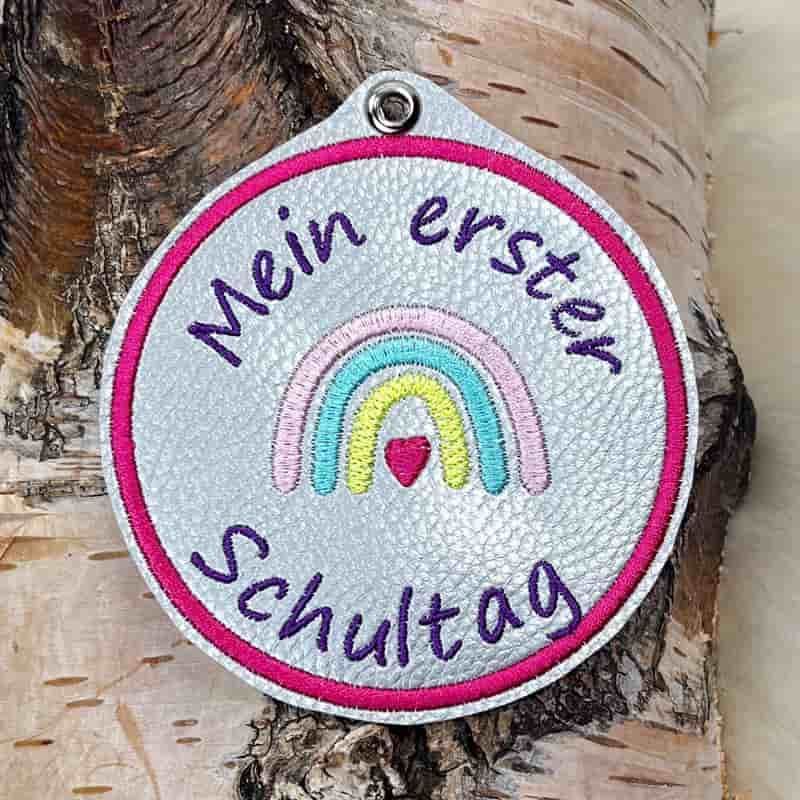 Button für die Einschulung mit einem Regenbogen.