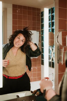 Vrouw draagt handgemaakte rode leren Sassy Stitch riem van Atelier Loulou