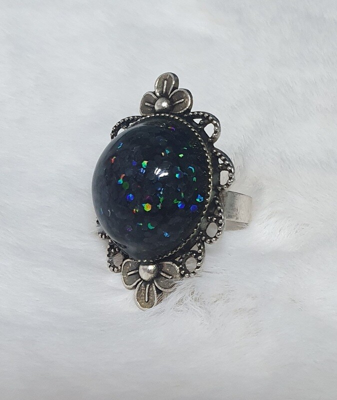 Bague ajustable fantaisie fleurs en métal vieilli. Gros cabochon bombé en résine noire et paillettes. Fabrication artisanale. Modèle unique