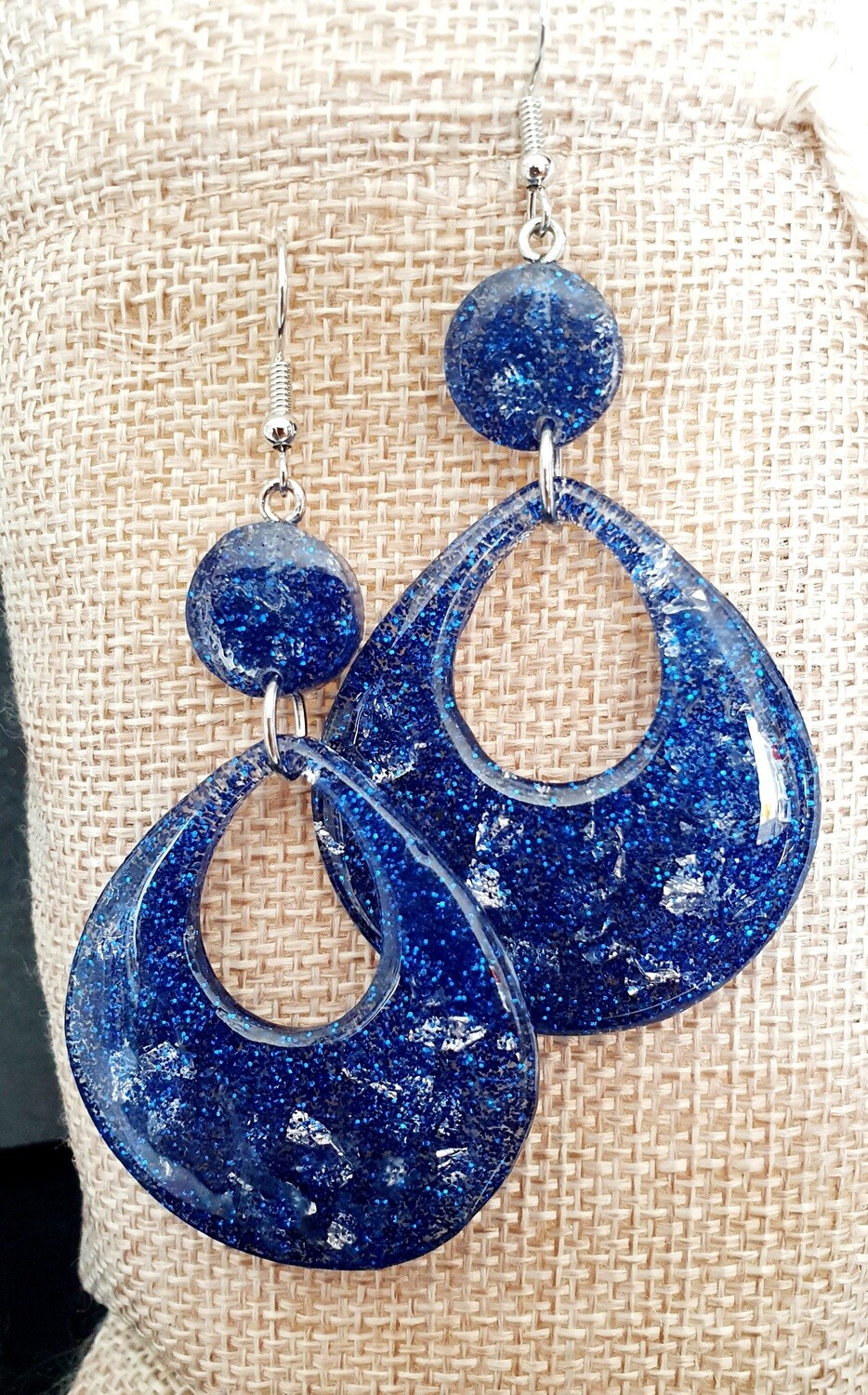 Boucles d&#39;oreilles gouttes 3,5cm/5,5cm en résine bleue pailletée et flocons d&#39;argent. Ultra féminines 💄 et très légères à porter. Crochets hypoallergéniques.
Fabrication artisanale. Modèle unique