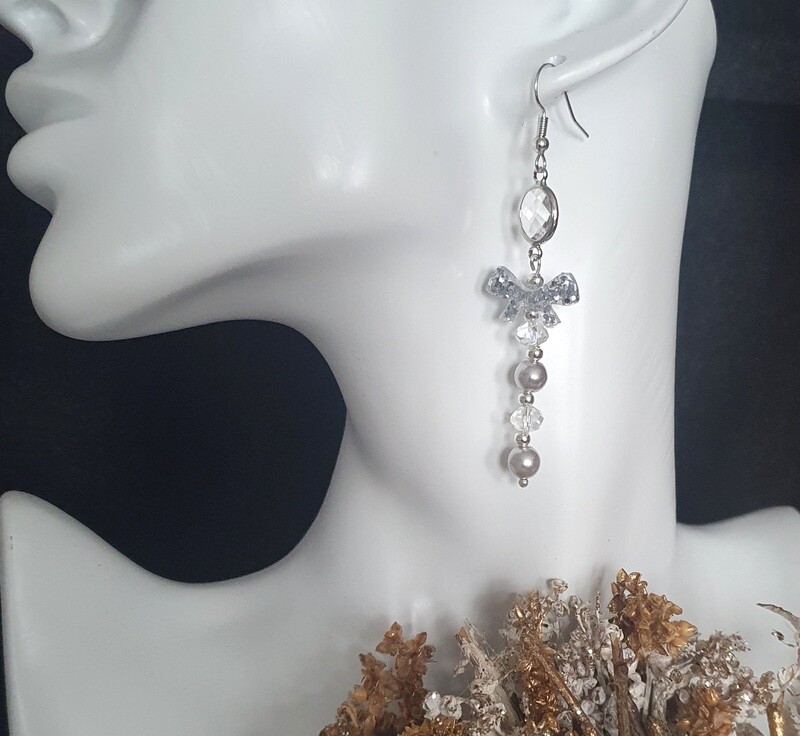 💖 Ravissantes boucles d'oreilles argentées. Perles argent nacrées et toupies en cristal. Petits nœuds papillons en résine et paillettes argentées. Fabrication artisanale. Exemplaire unique.