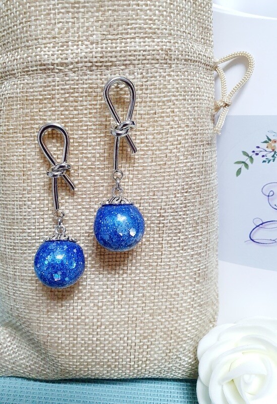 💙 Originales et légères, boucles d'oreilles nœuds argentés. Petites sphères en résine bleue saphir. Paillettes holographiques. Fabrication artisanale. Exemplaire unique.