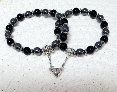 💘💘 Couple de bracelets extensibles pour les amoureux reliés par un petit coeur aimanté. Perles en véritable ONYX NOIR et HÉMATITE gris métal. Création artisanale. Exemplaire unique