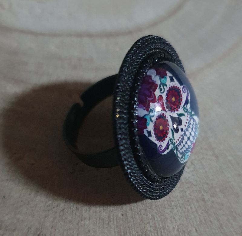 🇲🇽 Calaveras 🇲🇽 Bague ronde ajustable, noire. Cabochon bombé en verre. Motif Tête de mort multicolore, symbole de la culture mexicaine. Modèle unique.