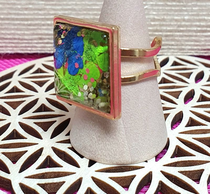 💐 Bague ouverte en acier doré inoxydable. Cabochon carré en verre bombé. Petites fleurs séchées bleues et vertes. Création artisanale. Modèle unique.