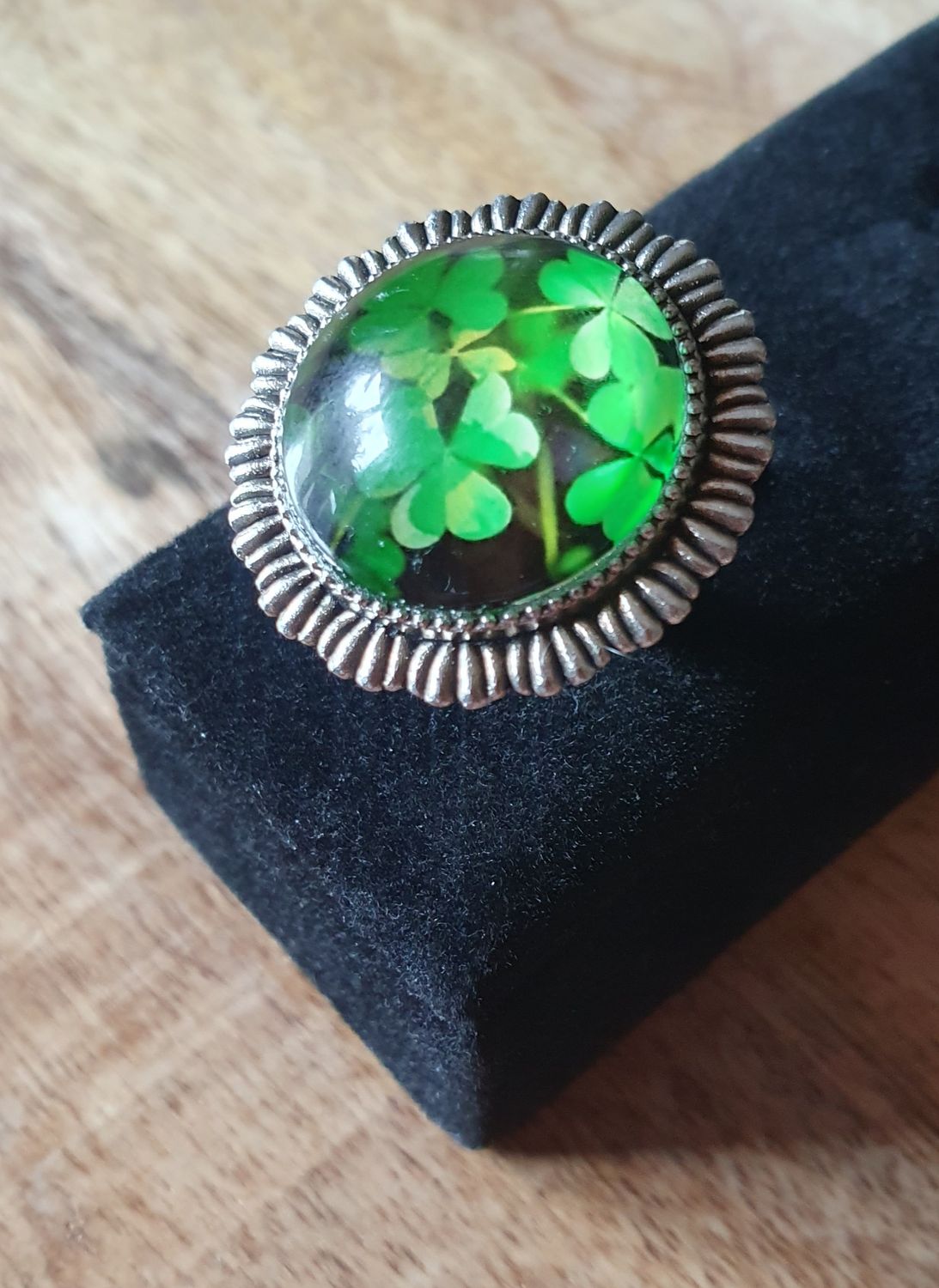 🍀 Bague ronde ajustable fantaisie en acier inoxydable. Cabochon rond bombé en verre. Motif trèfles 🍀 sur fond noir. Modèle unique.