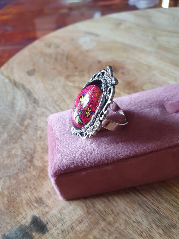 💐 Bague ovale fantaisie ajustable tête de mort fleurie, fuchsia et jaune. Symbole de la culture mexicaine. Acier inoxydable ciselé. Modèle unique.