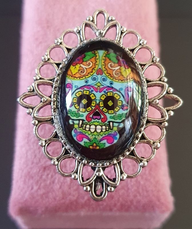 💙 COLLECTION CALAVERAS 💙 Bague losange ajustable en acier inoxydable ciselé. Cabochon ovale en verre bombé. Motif Tête de mort, symbole de la culture Mexicaine. Modèle unique.