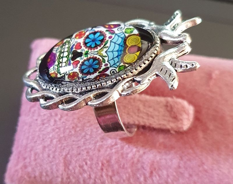 🦋 COLLECTION CALAVERAS 🦋 Bague ajustable colombes en acier inoxydable. Cabochon bombé ovale en verre. Motif Tête de mort multicolore. Symbole de la culture Mexicaine. Modèle unique