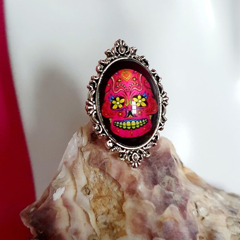 🇲🇽 COLLECTION CALAVERAS 🇲🇽 Bague ajustable ciselée en acier inoxydable. Cabochon bombé ovale. Motif Tête de mort fuchsia. Symbole de la culture Mexicaine. Modèle unique.