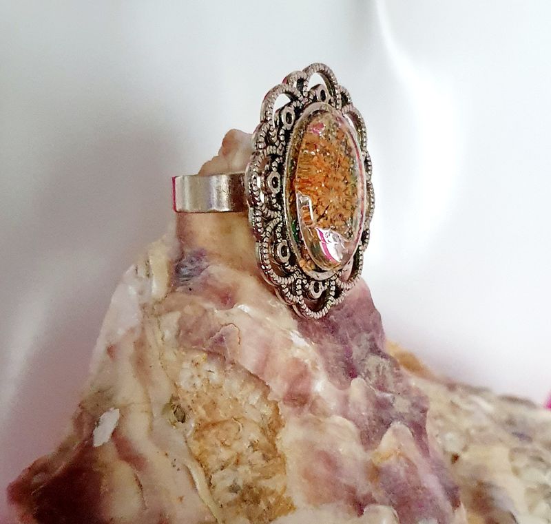 🌼 FLEURS SÉCHÉES 🌼 Bague ovale ciselée, ajustable en acier inoxydable. Fleurs séchées jaunes orangées, feuilles d'argent froissées. Création artisanale. Modèle unique.