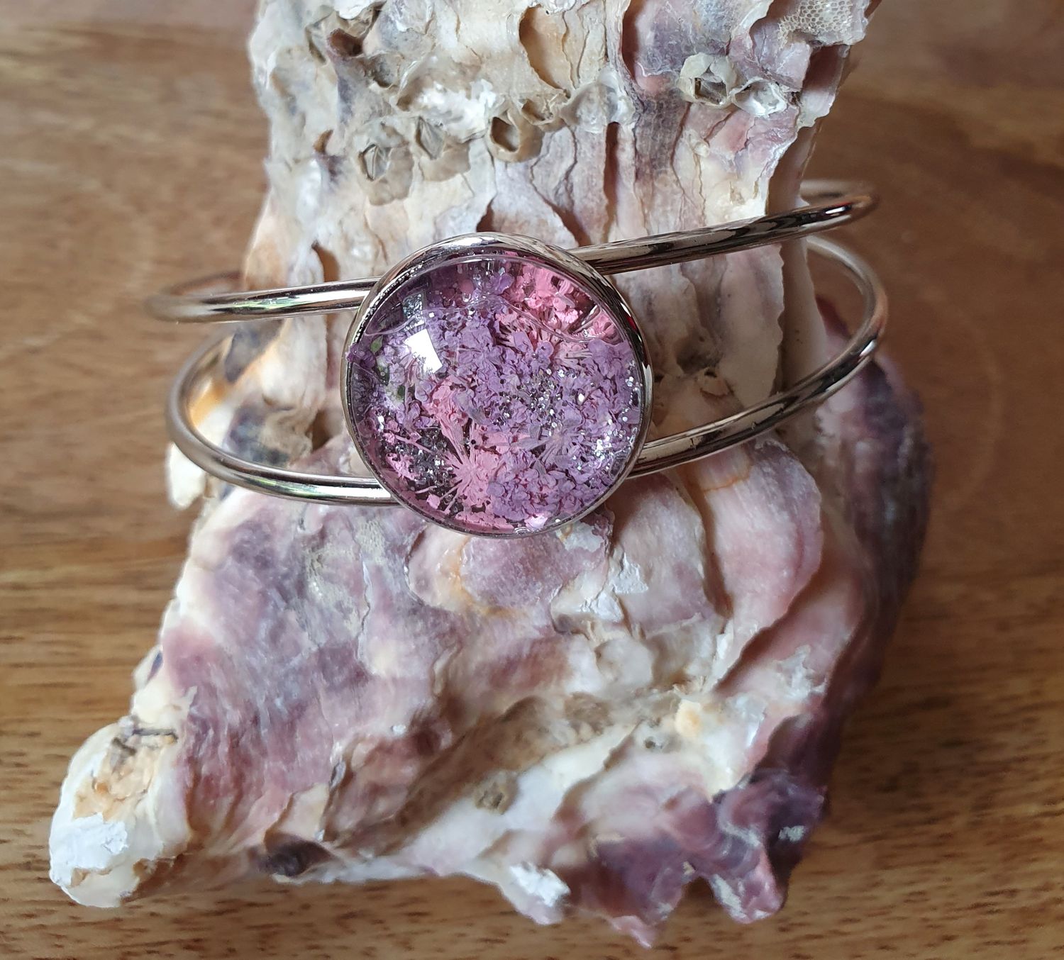 🌸 Bracelet rigide ouvert en acier inoxydable couleur argent. Cabochon  fleurs séchées roses/mauves et poudre d&#39;argent. Création artisanale. Modèle unique.