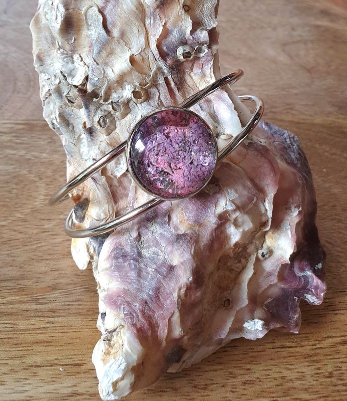 🌸 Bracelet rigide ouvert en acier inoxydable couleur argent. Cabochon  fleurs séchées roses/mauves et poudre d'argent. Création artisanale. Modèle unique.