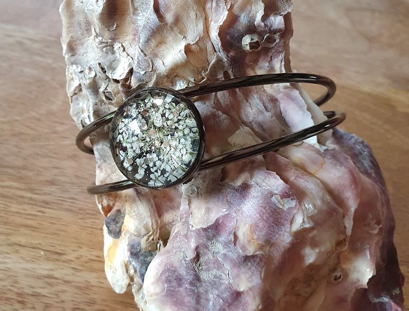 💖 Bracelet rigide ouvert en acier inoxydable couleur bronze. Cabochon rond. Fleurs séchées blanches et paillettes dorées. Création artisanale. Modèle unique.