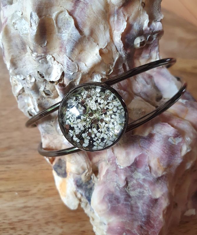 💖 Bracelet rigide ouvert en acier inoxydable couleur bronze. Cabochon rond. Fleurs séchées blanches et paillettes dorées. Création artisanale. Modèle unique.