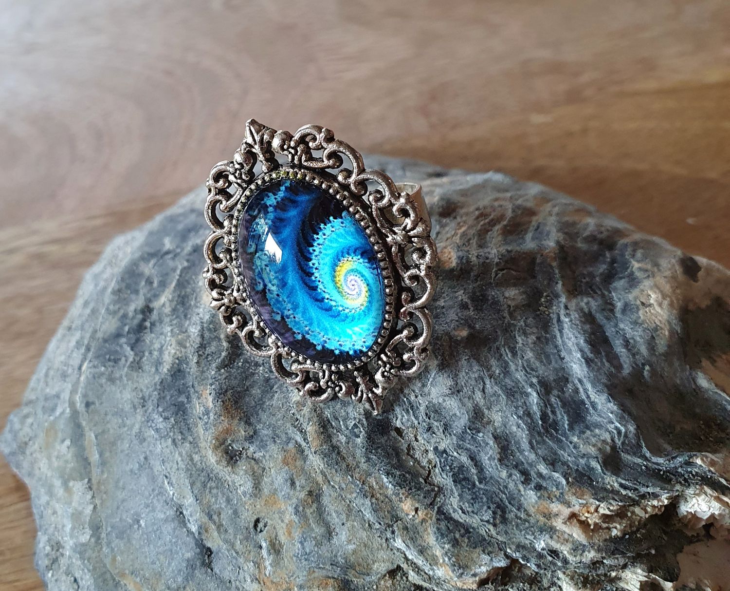 💙 GALAXIE 💙 Bague ajustable ovale en acier inoxydable. Cabochon bombé ovale en verre. Motif Galaxie bleue et jaune. Création artisanale. Modèle unique.