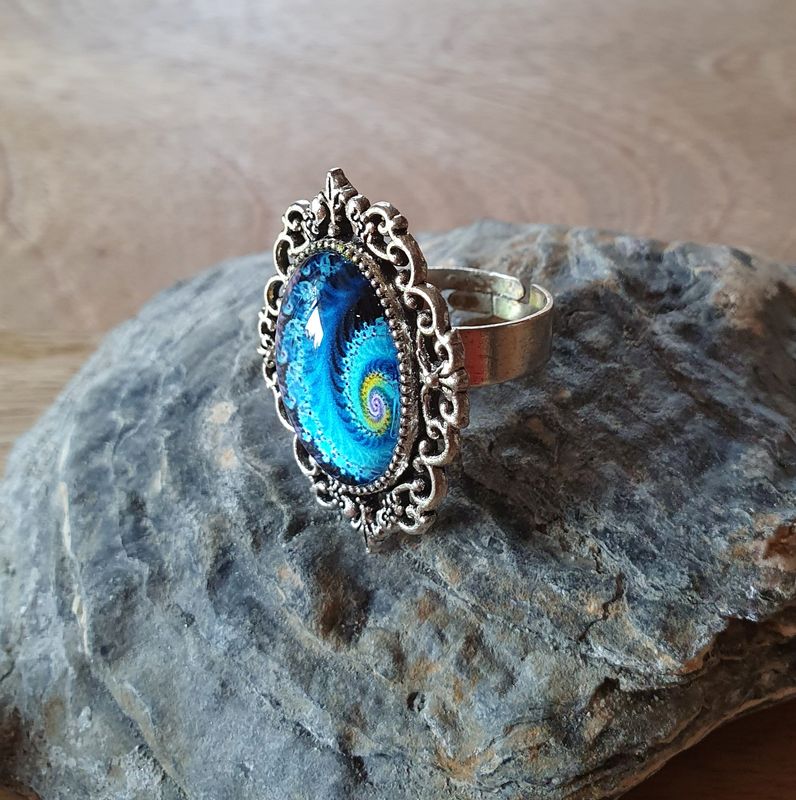 💙 GALAXIE 💙 Bague ajustable ovale en acier inoxydable. Cabochon bombé ovale en verre. Motif Galaxie bleue et jaune. Création artisanale. Modèle unique.