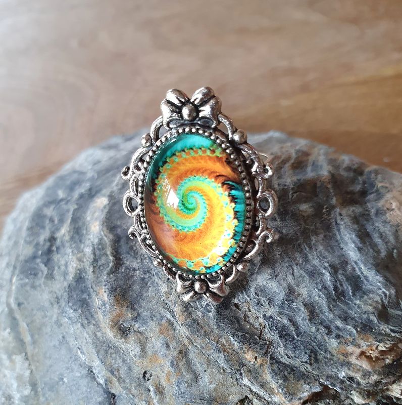 🧡💙 GALAXIE 💙🧡 Bague ajustable ovale en acier inoxydable. Cabochon bombé ovale en verre. Motif Galaxie orange/turquoise. Création artisanale. Modèle unique.