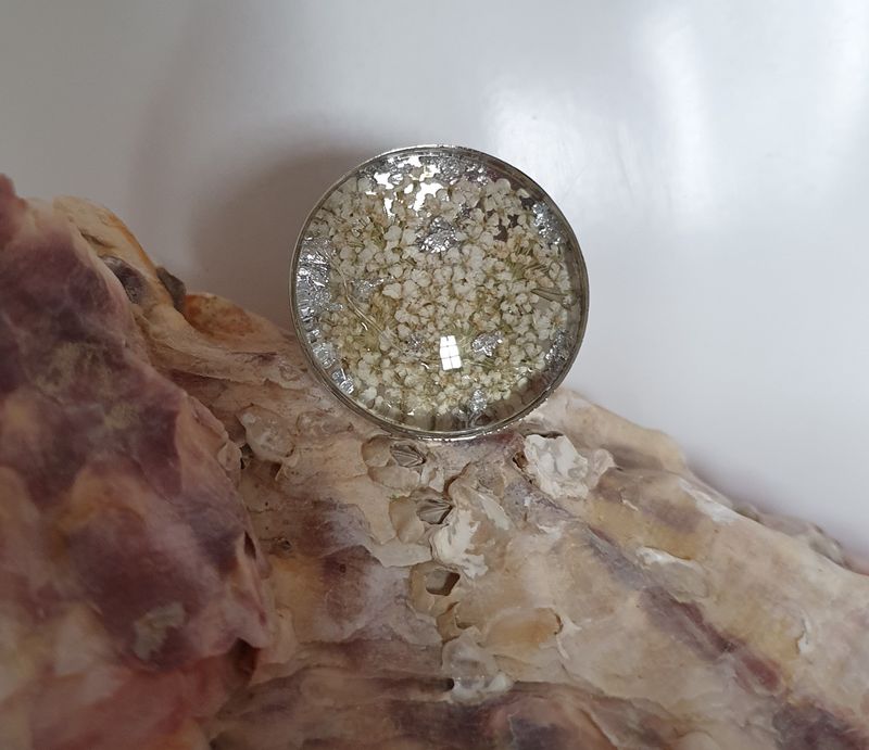 💖 Bague ronde ajustable en acier inoxydable. Véritables petites fleurs sechées blanches et feuilles d&#39;argent froissées. Cabochon diam.2,5cm. Création artisanale. Modèle unique.