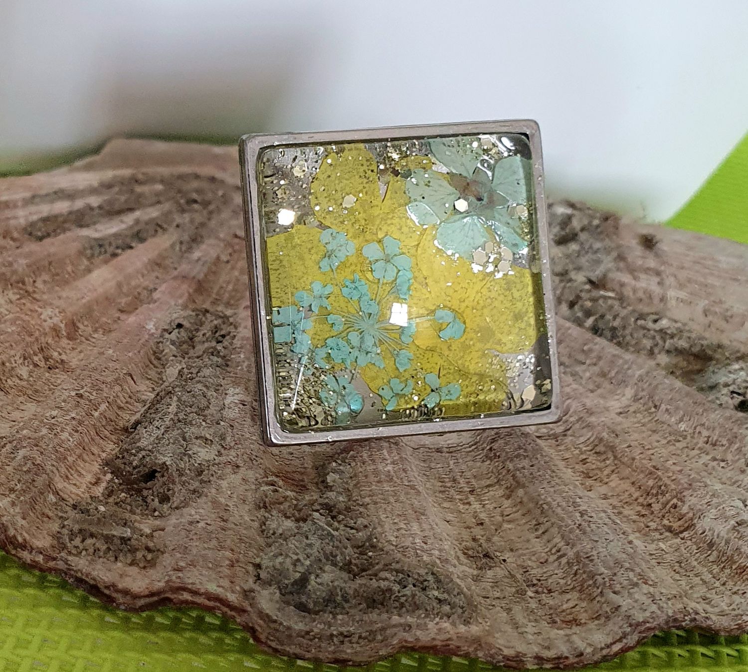 🌼 Bague carrée ajustable en acier inoxydable. Cabochon bombé en verre. Véritables petites fleurs sechées turquoises/jaunes et paillettes. Création artisanale. Modèle unique