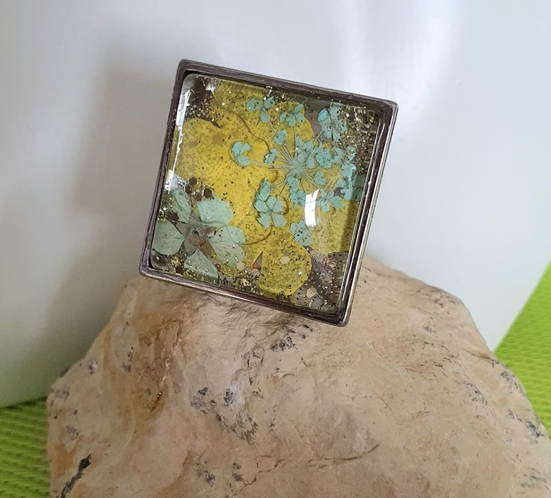 🌼 Bague carrée ajustable en acier inoxydable. Cabochon bombé en verre. Véritables petites fleurs sechées turquoises/jaunes et paillettes. Création artisanale. Modèle unique
