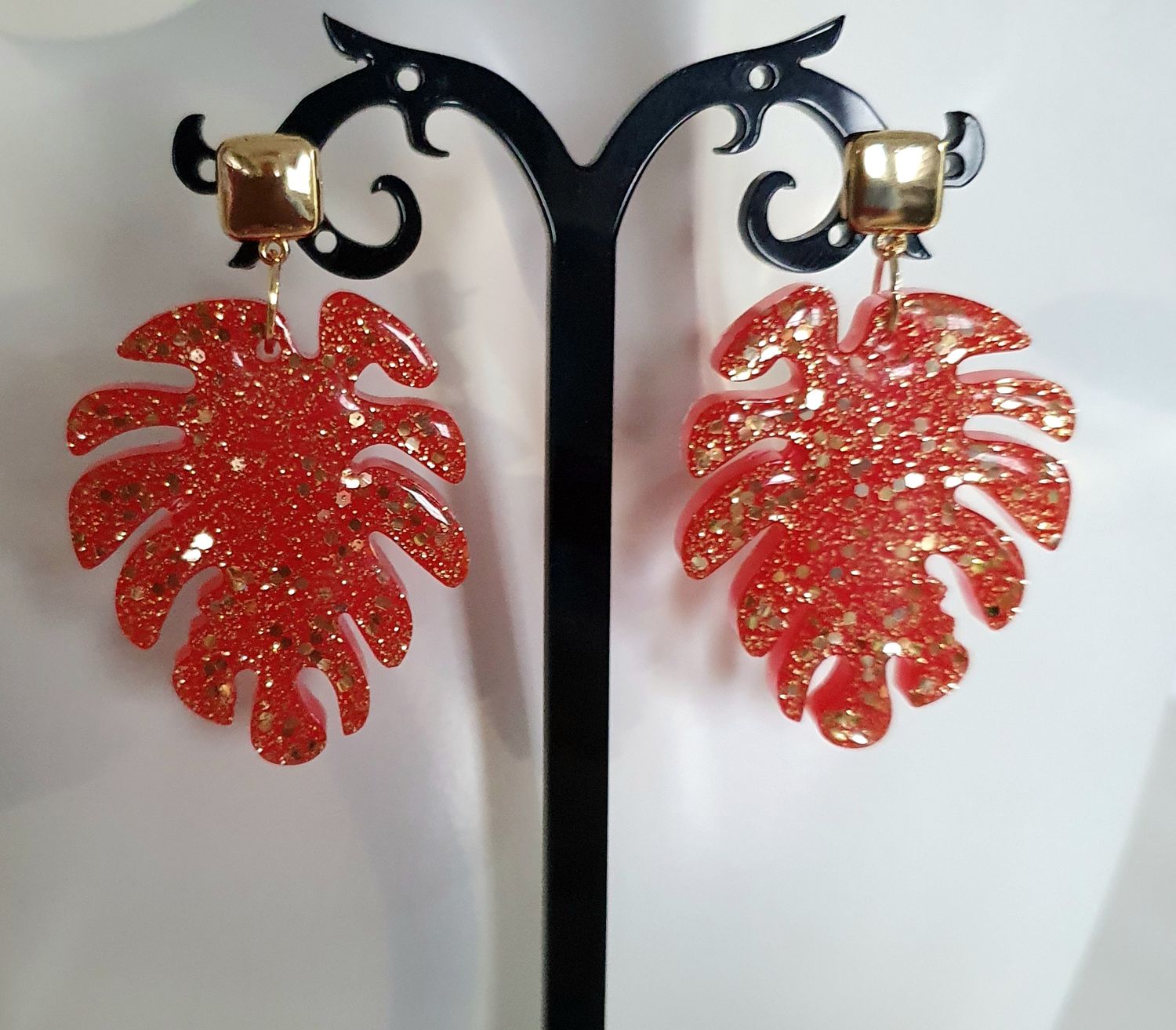 🌿 Boucles d&#39;oreilles grandes feuilles de Monstera en résine rouge orangée et paillettes dorées. Ultra légères à porter. Création artisanale. Modèle unique.