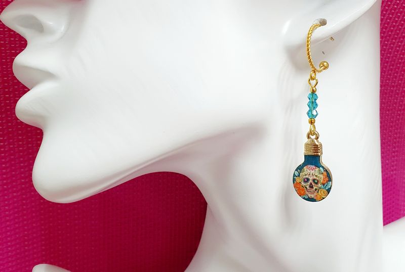 💎 Calaveras symbole de la culture Mexicaine. Créoles ouvertes torsadées en acier doré inoxydable. Pendentifs ampoules 💡 motifs Calaveras multicolores. Modèle unique.