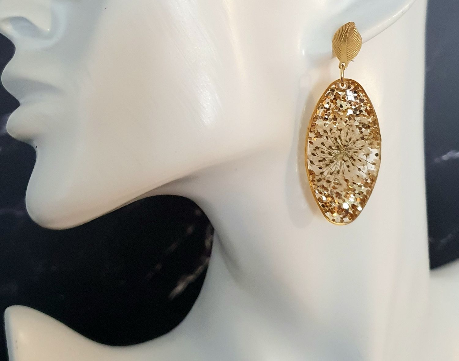 🤩 Boucles d&#39;oreilles ovales dorées. Résine transparente, fleurs de carottes 🥕 et paillettes dorées.  Ultra légères à porter 🪶🪶 Création artisanale. Exemplaire unique.