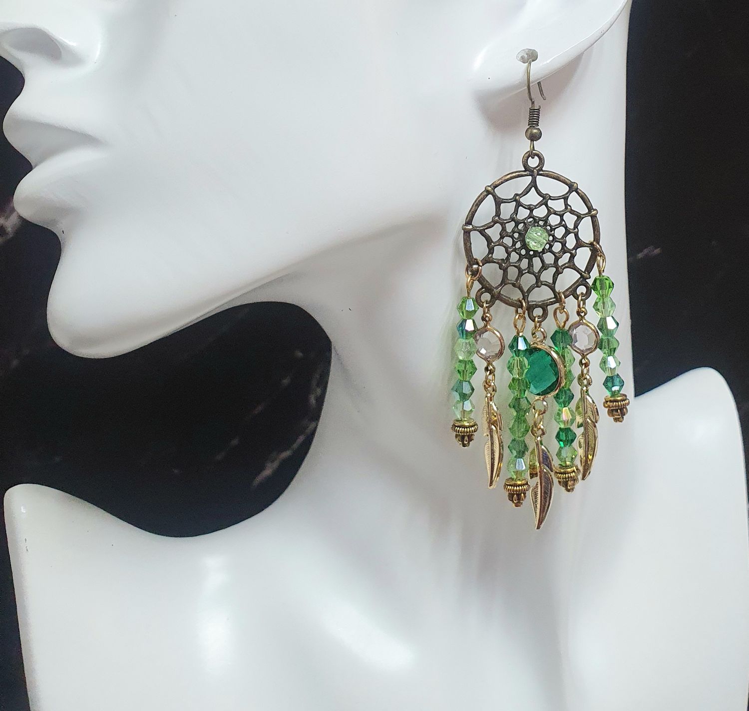 🍀 Magnifiques boucles d&#39;oreilles Attrape-rêves couleur bronze. Perles toupies en un dégradé de verts cristal et plumes dorées. Création artisanale. Exemplaire unique.
