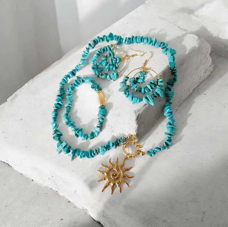 Bracelet extensible T.standard 18,5cm. Chips baroques en pierre reconstituée teintée turquoise. Perle cache-noeud rectangulaire impression fleurs. Création artisanale. Modèle unique.