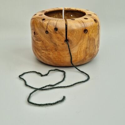 Wooden yarn bowl for knitting or crocheting. The functional holes of the yarn bowl have been incorporated into a design inspired by the Atomic Age graphics of the 1950's. Hand turned from a highly figured piece of spalted beech. Pyrography has been used to apply the minimal graphic decoration.
