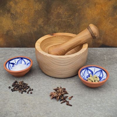 Handcrafted elm pestle and mortar set, styled with aromatic spices. Sturdy, traditional wooden kitchen tool.