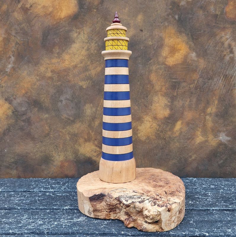 Large birch Lighthoose with blue stripes, red finial, two-tiered pyrographed windows, on a textured oak burr live-edge base