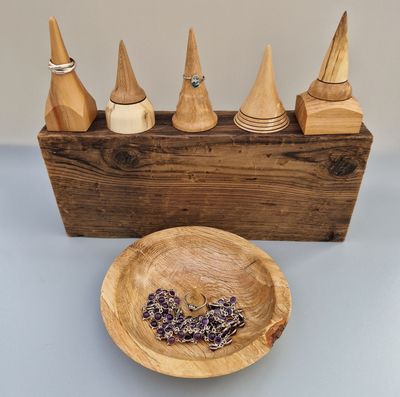 Wooden ring holders and an oak jewellery bowl with upright ring holder in the centre.