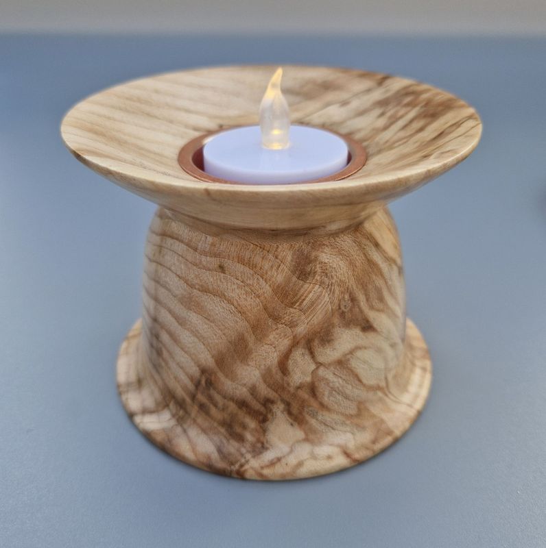Wide-rimmed tealight holder in spalted sycamore with copper insert; warm tones and soft sheen.