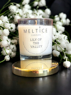 Glass jar with white candle, scented with lily of the valley.