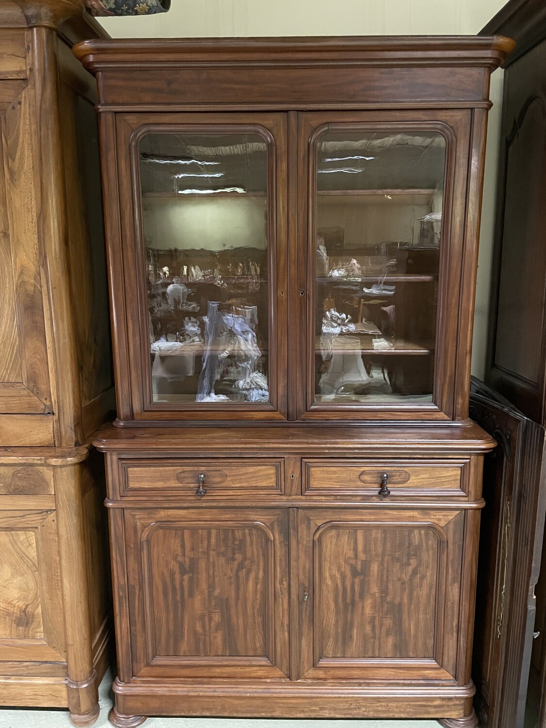 Magnifique buffet deux corps en placage d'acajou flammé  : vantaux vitrés en partie haute, deux tiroirs en ceinture et deux vantaux pleins en partie basse, pieds boules. XIXème. 208.5 x 121 x 52 cm