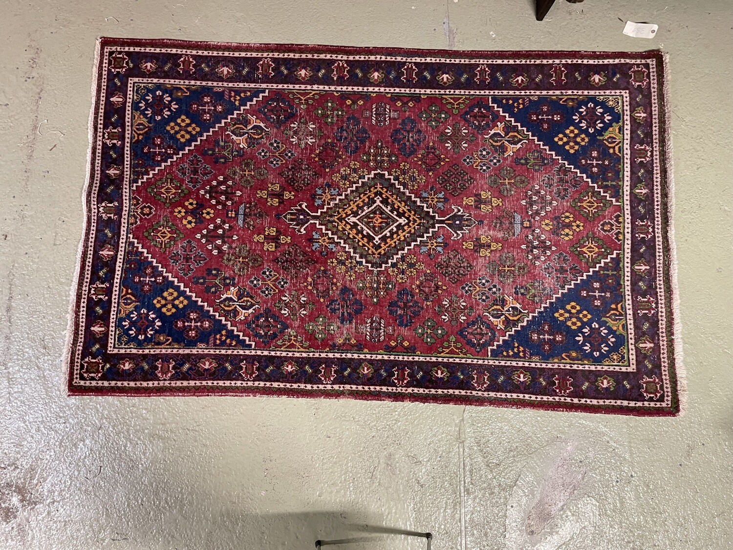 Tapis en laine à fond rouge et décor floral polychrome. 220 x 130
cm.