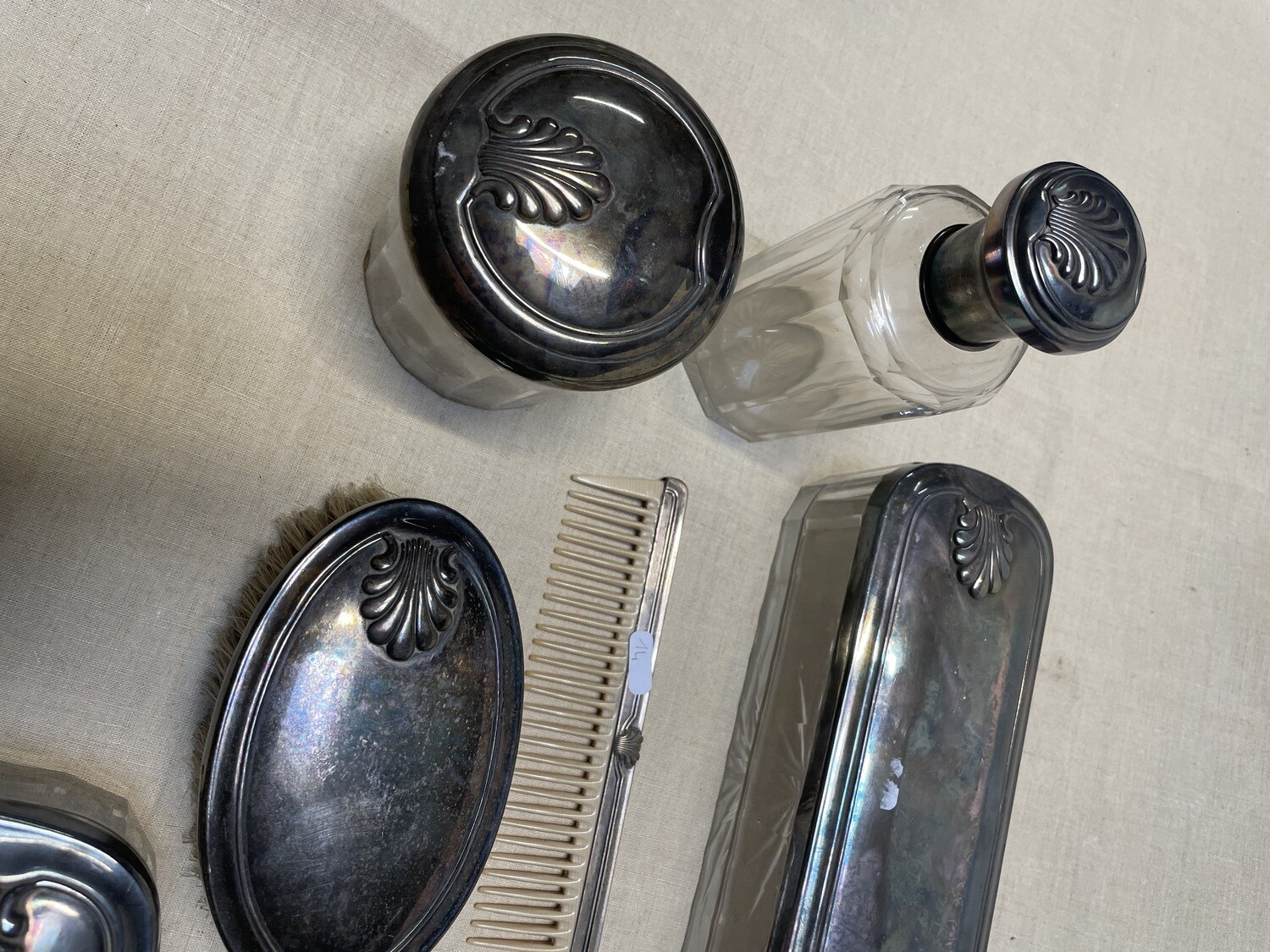 4 flacons couverts à décor de palmettes, 1 peigne avec monture assortie, une brosse, un miroir face à main  (27cm) - En verre taillé et métal argenté - magnifique ensemble