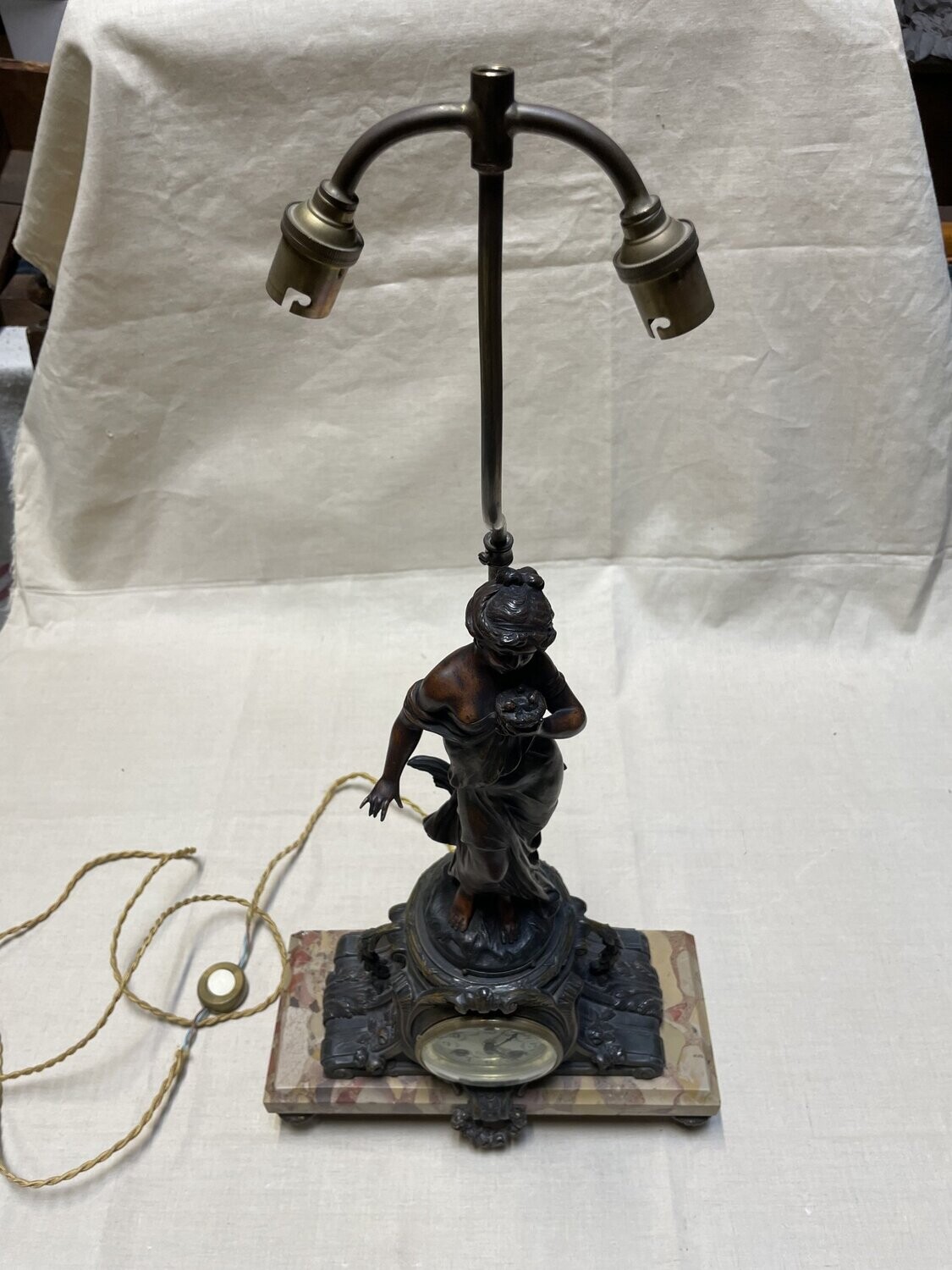 Pendule montée en lampe en régule d'après L & F MOREAU, titrée " Le Nid", h : 50,5 cm pour la statue et 69 cm pour la lampe.